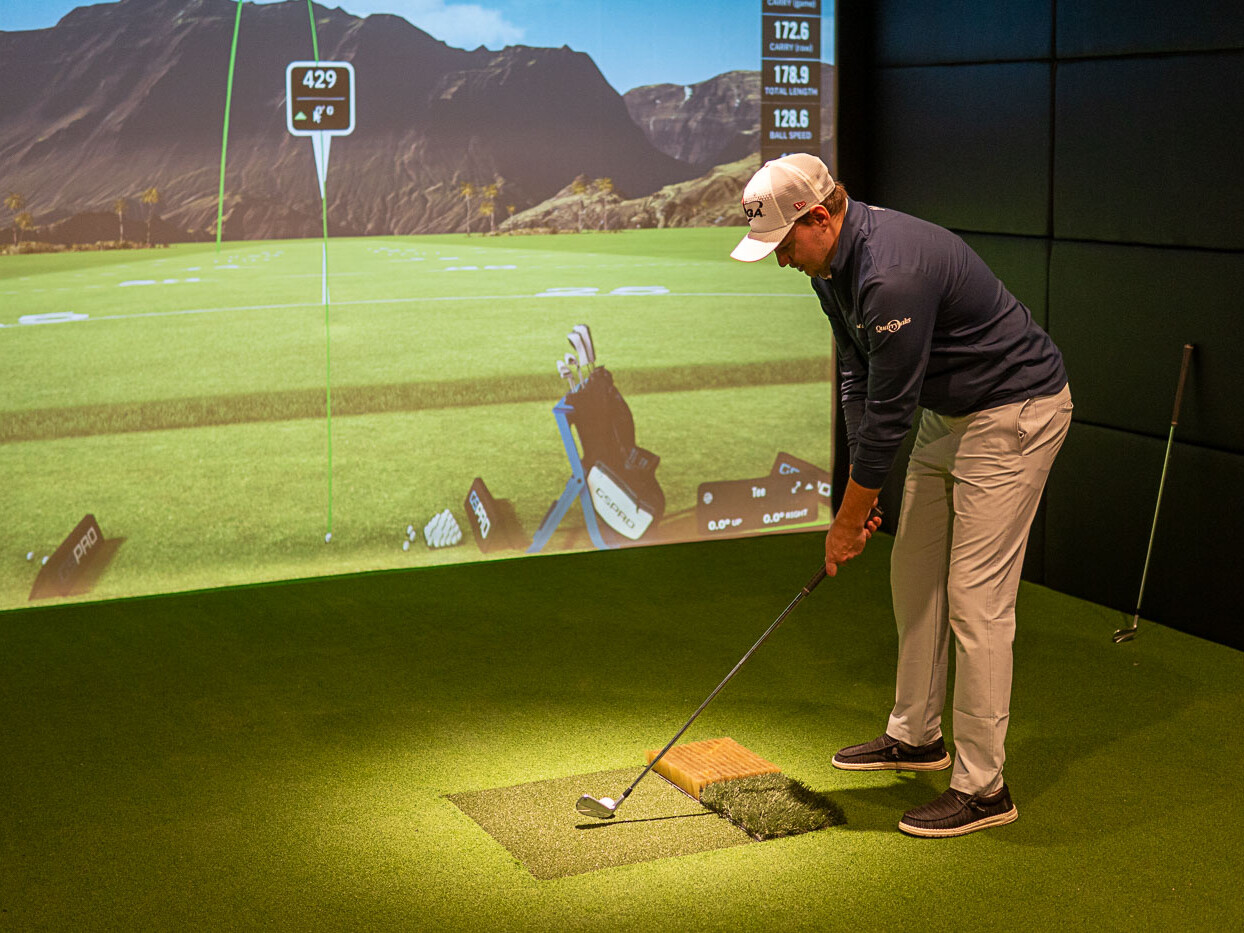 Golfer Lines up Shot in Front of a Indoor Golf Simulator Screen